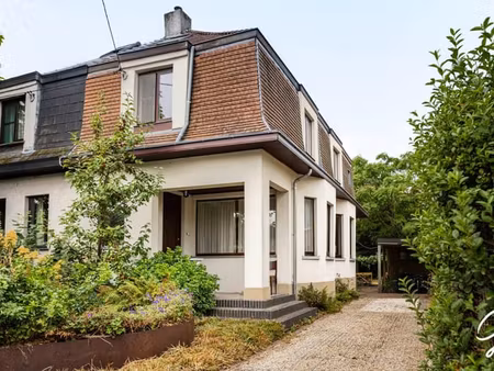 maison mitoyenne avec jardin verdoyant dans une rue calme