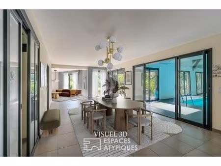 villa contemporaine avec piscine intérieure dans un écrin de verdure.