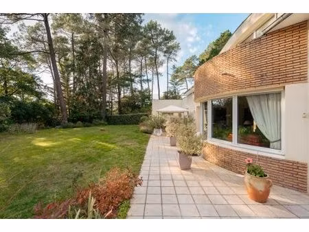 maison d'architecte avec jardin paysager dans un environnement boisé.
