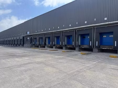 magazijn 6.879m² met 8 laadkades en kantoor van 408m² met ruime parking te huur