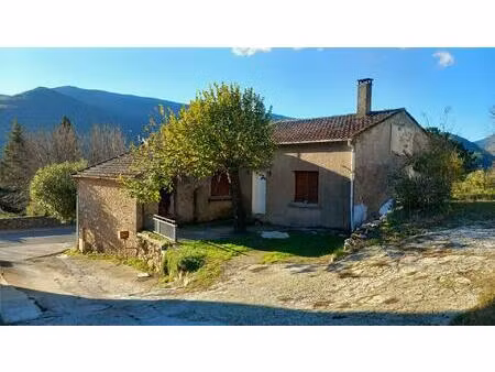 maison en pierres sur garage avec terrain constructible attenant.