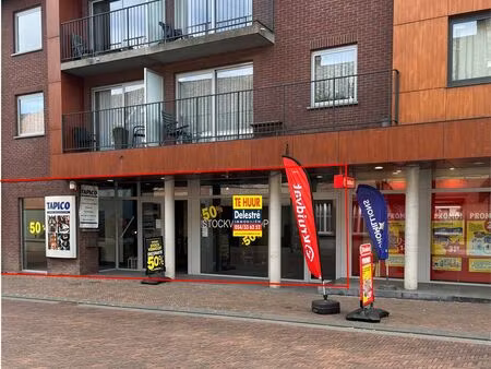 modern winkelpand naast kruidvat met parking