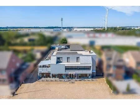 handelsruimte met luxe duplex-appartement en verhuurde loodsen op het industrieterrein in 