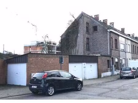 construction semi-ouverte avec 3 garages et petit jardin