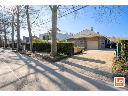 degelijke open gelijkvloerse woning met inpandige garage en grote tuin op een groene toplo