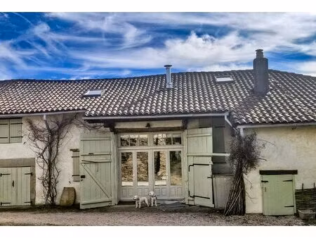 jolie maison en pierre avec une piscine  garage et parking extérieur.