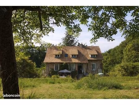 maison au milieu d’un grand jardin avec bois