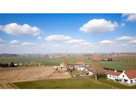 bouwgrond mét 2 loodsen & panoramisch zicht op de velden