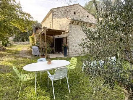 maison en pierre rénovée avec jardin arboré.