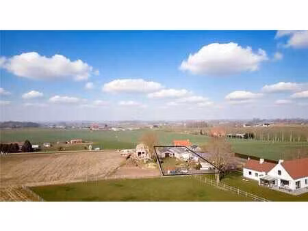 bouwgrond mét 2 loodsen & panoramisch zicht op de velden