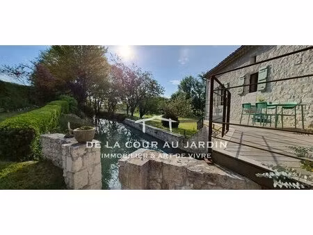 moulin restauré au coeur d'un écrin de verdure.