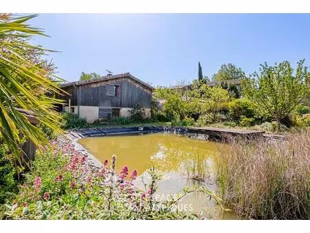 maison écologique avec bassin naturel et jardin paysager