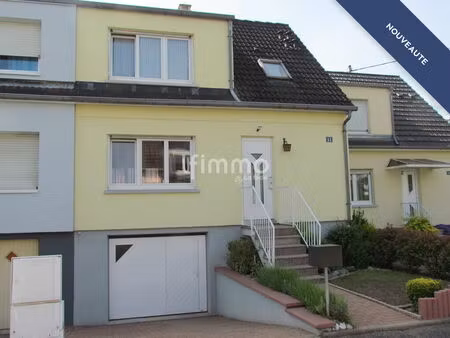 maison accolée avec un garage et un jardin
