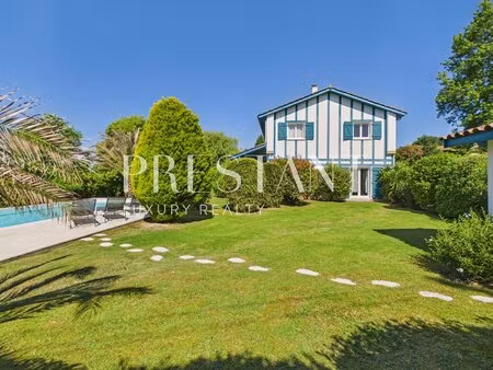maison familiale de 275 m² avec un jardin paysagé et piscine chauffée.