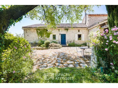 batisse en pierre avec piscine dans un écrin de verdure