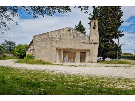 un entrepôt édifié sur terrain plat en partie arboré.