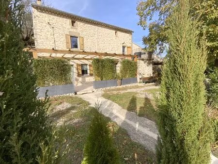 maison en pierre rénovée avec jardin arboré.