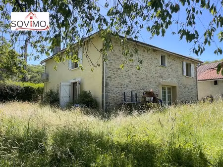 dans un endroit verdoyant  ancienne grange en pierre convertie en habitation avec terrain