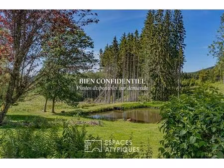 ferme vosgienne et son étang dans un cadre bucolique
