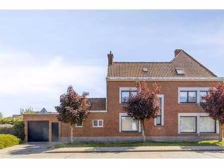 une charmante maison avec un jardin confortable et un garage