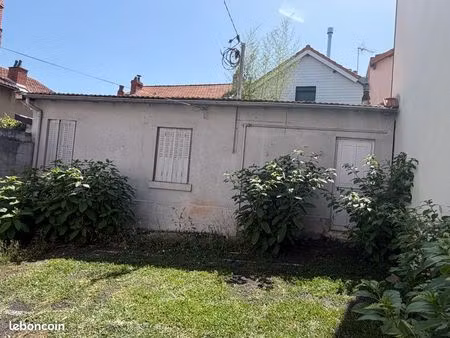 un ensemble composé d’une petit maison et deux garages