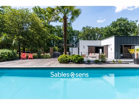 villa contemporaine avec piscine nichée dans un parc boisé