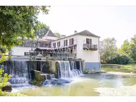 la maison du moulin  située au bord de la rivière dropt  surplombe son lac et s’étend au..