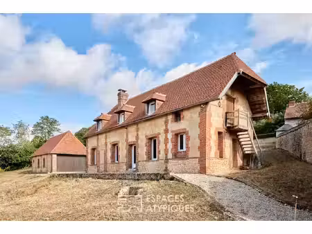 maison en pierre rénovée et dépendances face au paysage vallonné