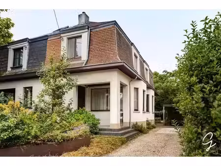 maison mitoyenne avec jardin verdoyant dans une rue calme