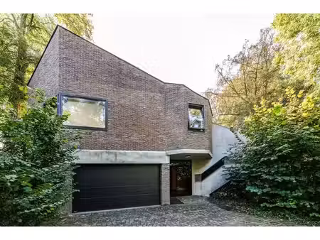 villa des '70 aux accents brutalistes  avec un jardin boisé