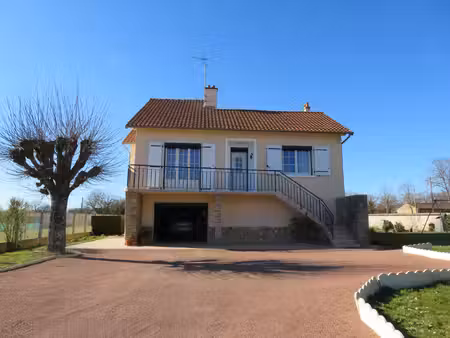 maison élevée sur sous-sol avec garage et jardin