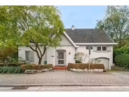 villa élégante d'angle avec jardin aménagé et garage.