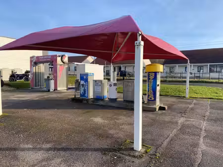 centre de lavages situé dans une zone commerciale  entre un noz et un opticien