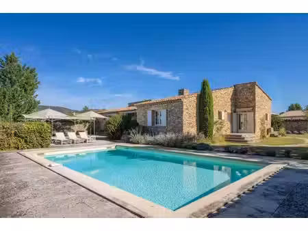 maison en pierre avec piscine et joli jardin paysager.